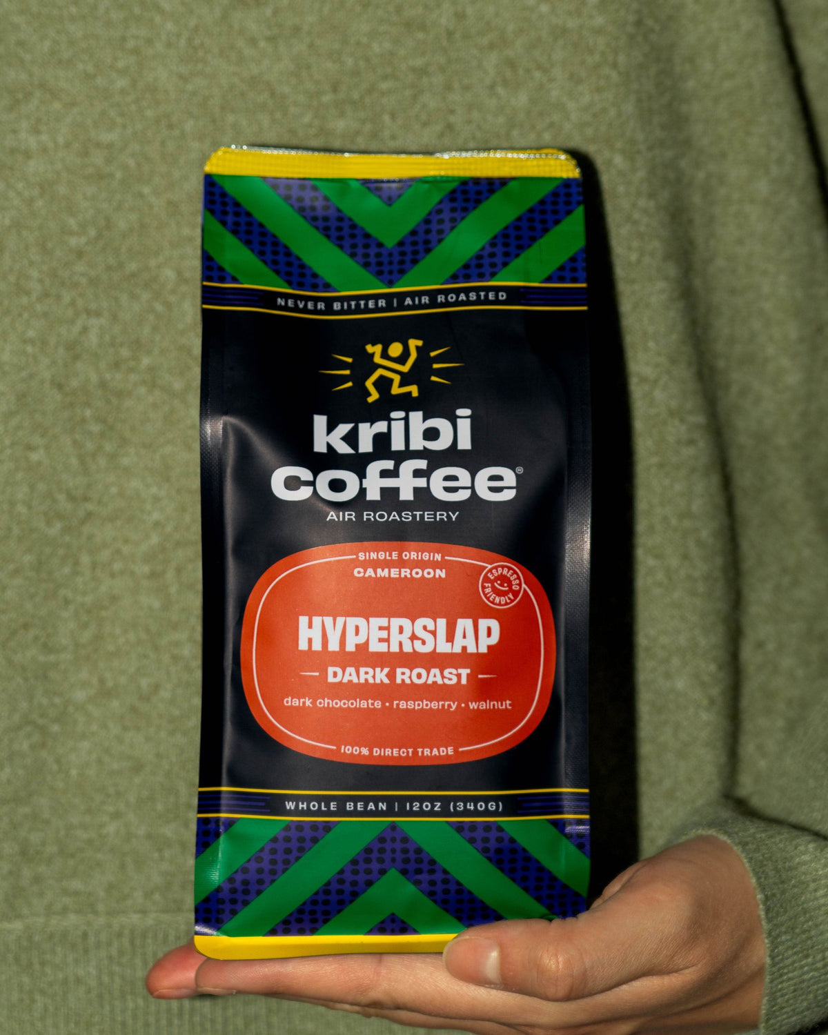 A hand holding out a bag of Hyperslap dark roast